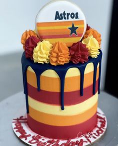 a multicolored cake with stars and flowers on top is sitting on a table