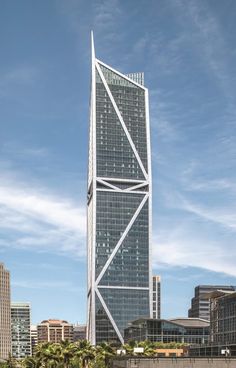 a very tall building sitting in the middle of a large body of water with palm trees around it