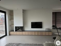 a living room with a flat screen tv mounted on the wall next to a fireplace