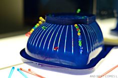 a blue vase sitting on top of a table next to some colored pencils and toothbrushes