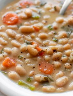 a white bowl filled with beans and carrots