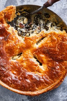 a pie is being cooked in a skillet with a spatula on the side