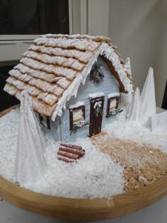 a gingerbread house made to look like it is in the middle of some snow