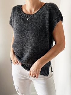 a woman wearing white jeans and a black sweater