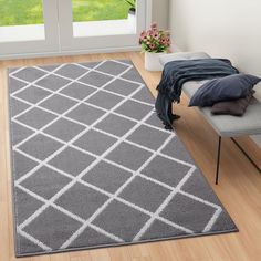 a grey rug with white squares on it in front of a sliding glass door and window