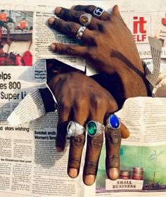 two hands with rings on top of newspaper