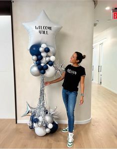 a woman standing next to a giant balloon and starfish decoration in an office lobby