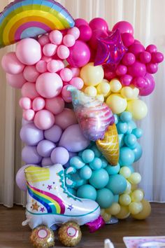 a bunch of balloons that are in the shape of an ice cream cone and rainbow