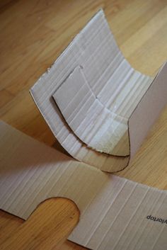 an open cardboard box sitting on top of a wooden floor next to a piece of paper