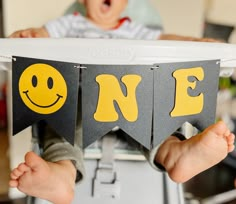 a baby sitting in a highchair with two flags that say one