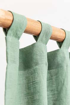 a green curtain hanging from a wooden rod