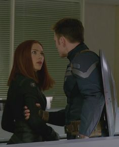 captain america the winter soldier and black widow in an office setting with two people looking at each other