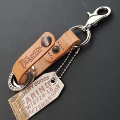 a leather keychain with a tag attached to it