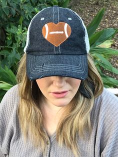 a woman wearing a hat with a football heart on it