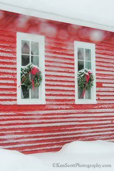 two windows with wreaths on them in the snow