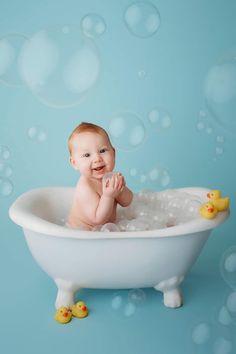 a baby sitting in a bathtub with soap bubbles