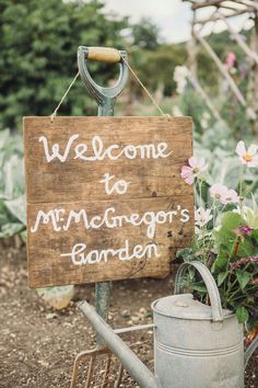 a wooden sign that says welcome to minnesota's garden next to a watering can