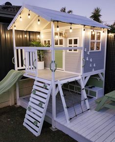 a small house with a slide in the back ground and lights on it's roof