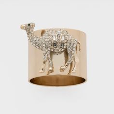 a gold ring with a camel in the middle and small diamonds on it's side