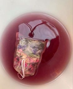 a bag filled with red liquid sitting on top of a white bowl