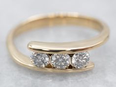 three stone diamond ring setting in yellow gold with white diamonds on each side and an invisible band