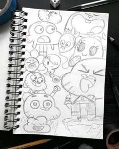 a drawing of angry birds on a notebook next to some markers and pencils,