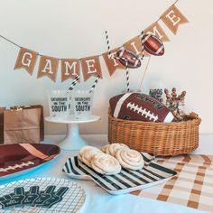 a table topped with football themed desserts and cake decorations for a game day party