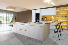 a modern kitchen with yellow accents and white counter tops, along with two stools