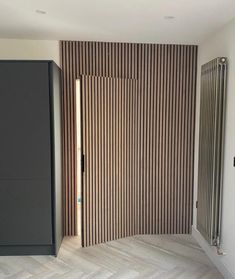 an empty room with wooden slats on the wall, and a closed door in the middle