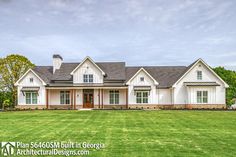 a large white house sitting on top of a lush green field