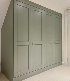 an empty room with green cupboards and carpeted flooring on the side wall