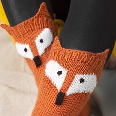 the legs of a woman wearing knitted socks with foxes on them, and black leggings