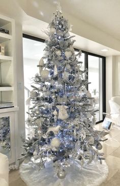 a silver and white christmas tree in a living room