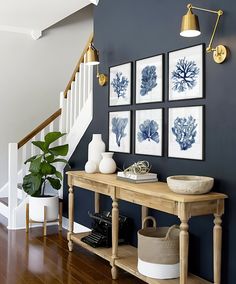 a room with blue walls and pictures hanging on the wall, along with a wooden table