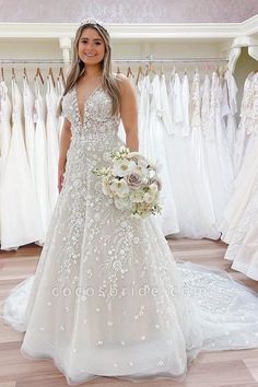 a woman standing in front of wedding gowns