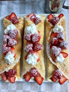 three crepes with strawberries and whipped cream