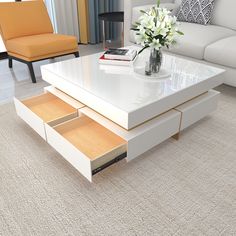 a white coffee table with two drawers in front of it and a couch behind it