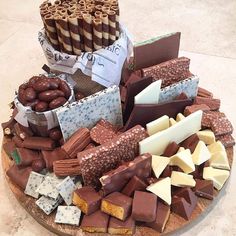 an assortment of different types of chocolates on a wooden platter