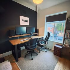 an office with a desk, chair and computer on top of it in front of a window