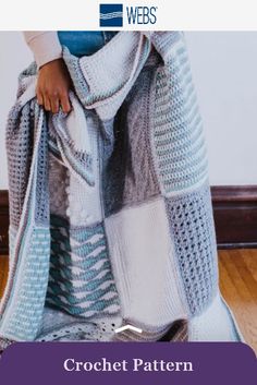 a woman is standing on the floor with her legs wrapped up in a crochet blanket