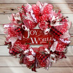 a red and white christmas wreath with the words joy to the world on it