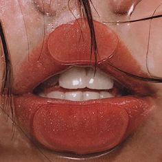 a woman's lips and nose are covered in red glitter, while she has her eyes closed