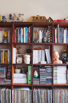 a bookshelf filled with lots of different types of records and cds on top of each shelf