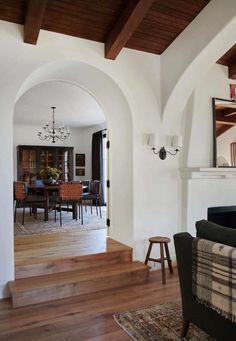 a living room filled with furniture and a fire place next to a dining room table