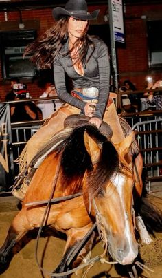 a woman riding on the back of a brown horse