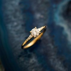 a diamond ring sitting on top of a blue surface