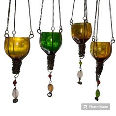 three different colored glass vases hanging from chains