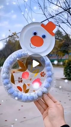 someone holding up a paper plate with a snowman on it