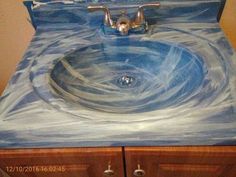 a bathroom sink painted with blue and white swirls