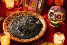 a table topped with candles and a hat on top of a wooden bowl filled with food